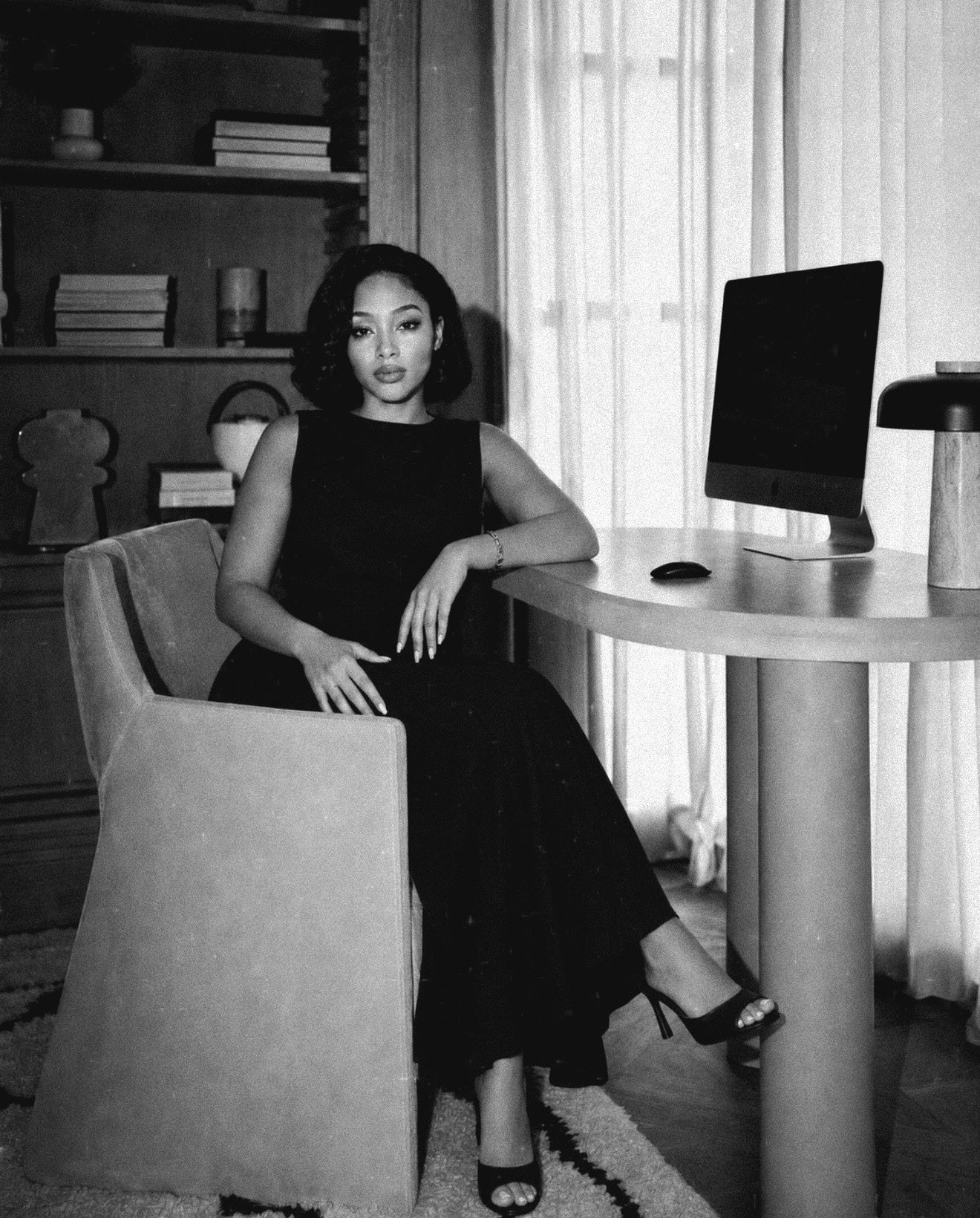 Refilwe Modibedi seated beside a desk.